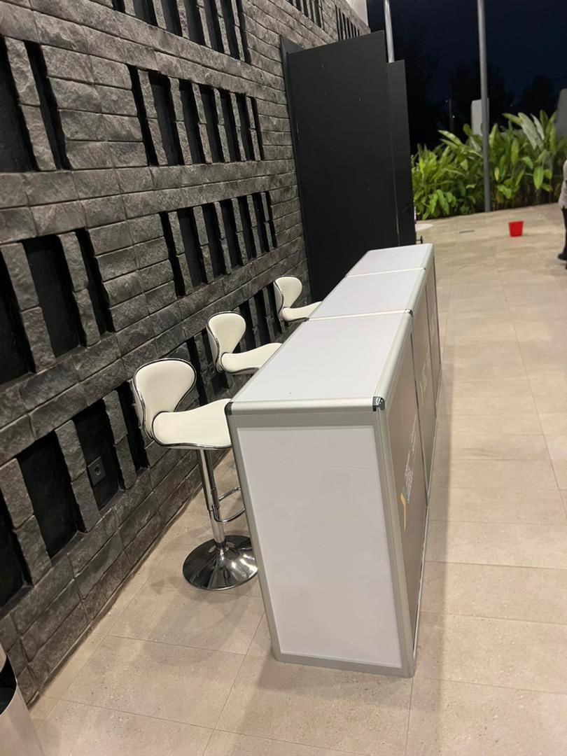 Folding counters and white bar stools set up for an evening event